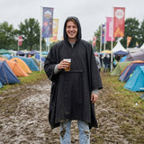 Pluvion heren regenponcho zwart gedragen op festival